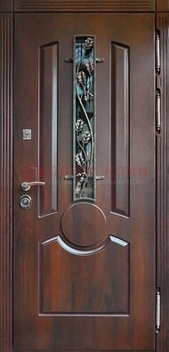 Темная железная дверь со стеклом и ковкой для кирпичного дома ДСК-136 в Омске